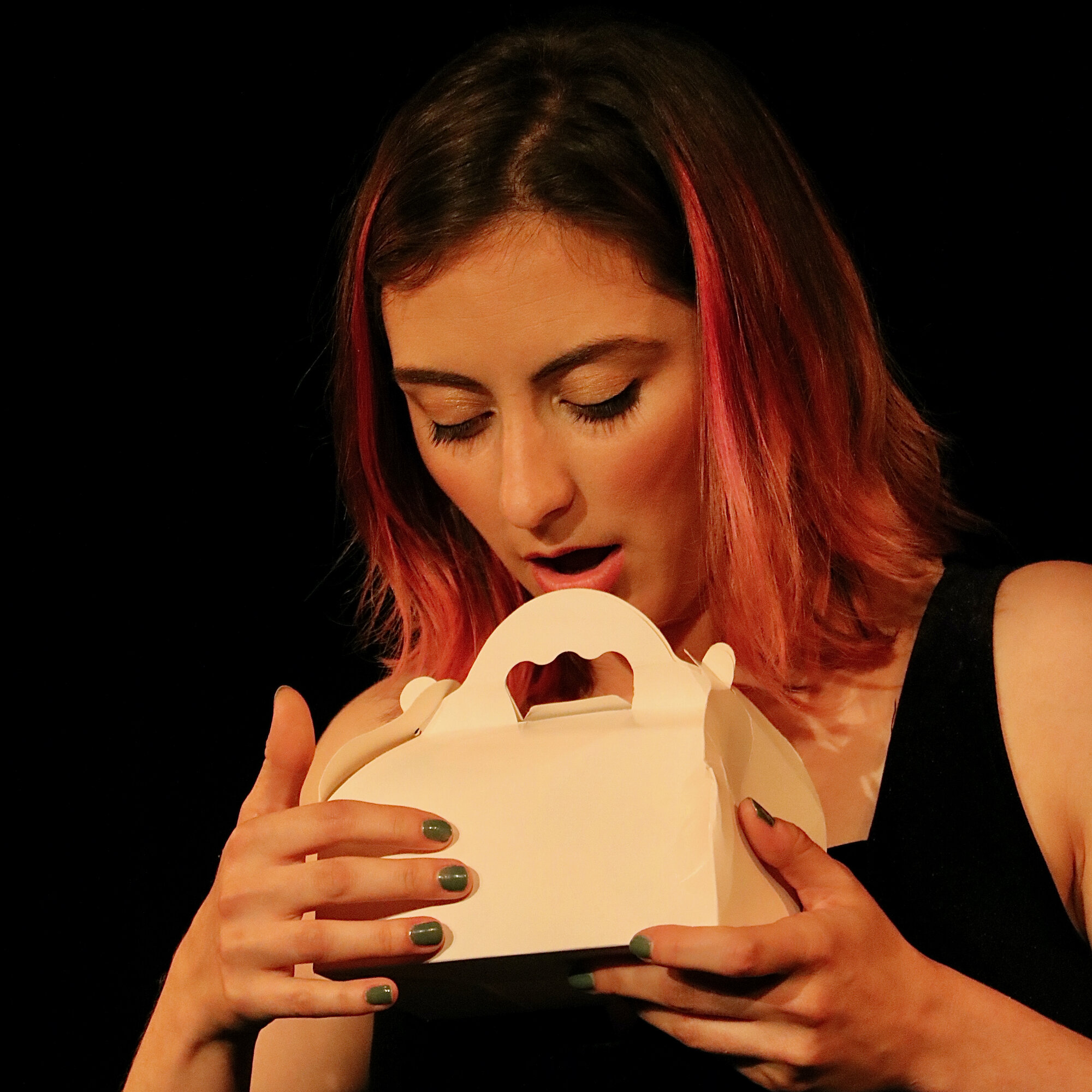 Julie Gamer sur scène dans Le Flan Pâtissier, rôle de Laure-Yann, tenant la boîte du flan